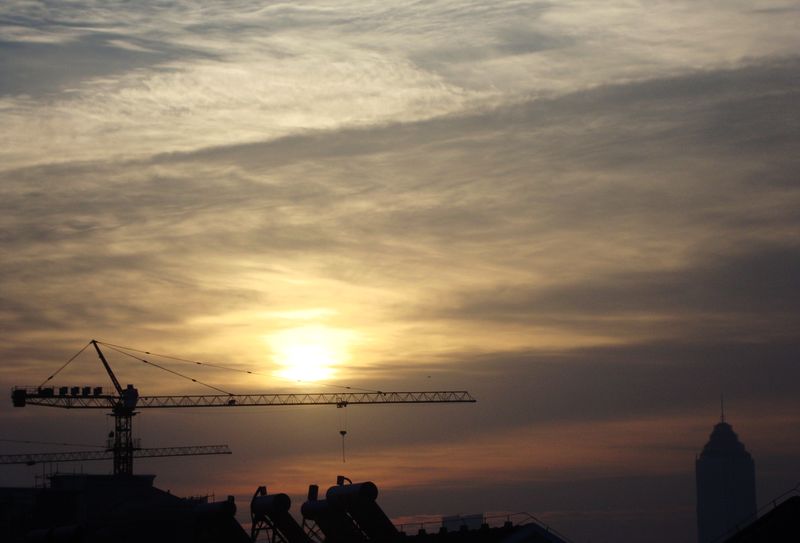 太阳出来，塔吊伸出长臂在紧张施工