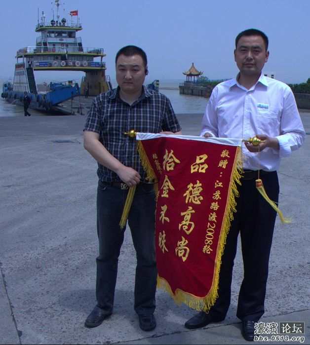 图为樊斌在值班长马元鹏的陪同下准备将锦旗送往2008轮的镜头