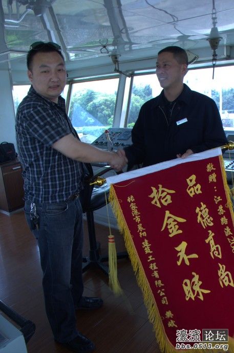 图为2008轮大副耿拥民接受樊斌锦旗的镜头