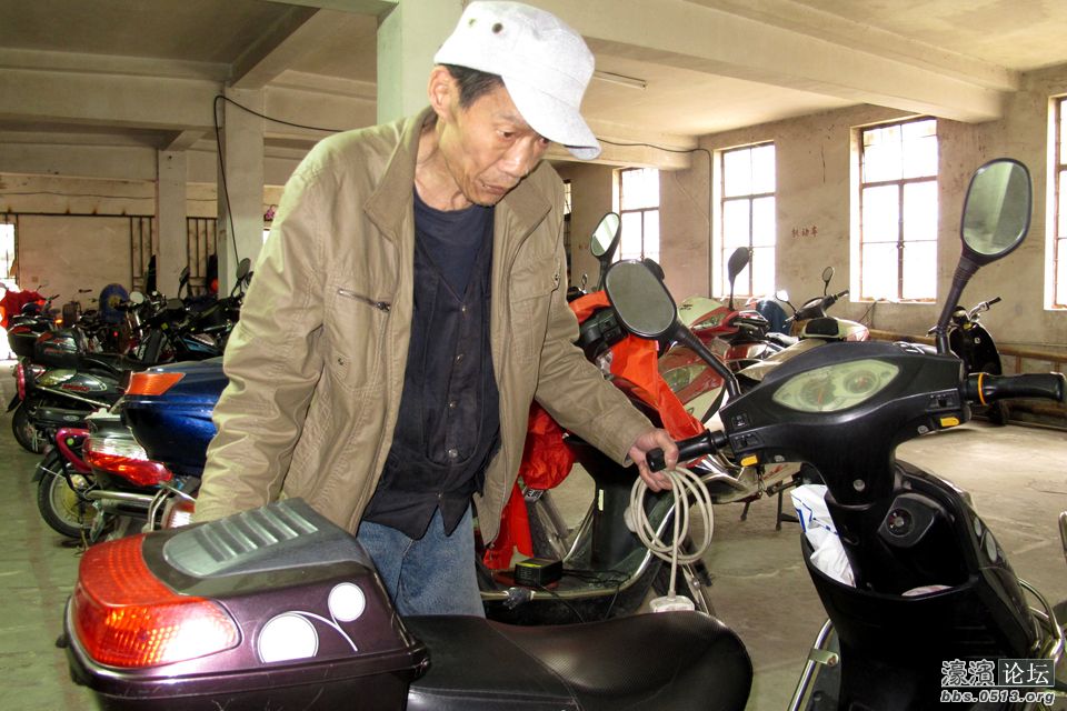 马建在整理电瓶车停放位置。