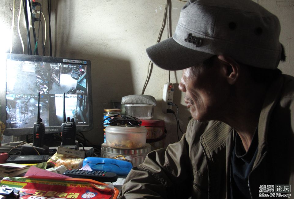 图为马建在休息室里看监控。