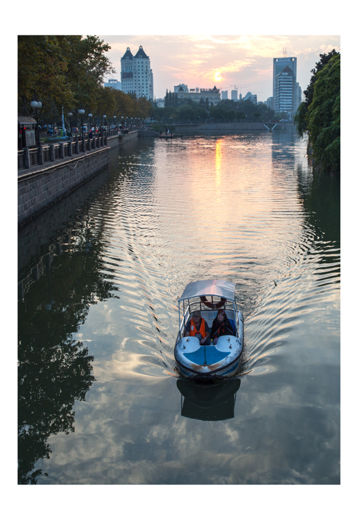 外国朋友坐着游船浏览濠河美景