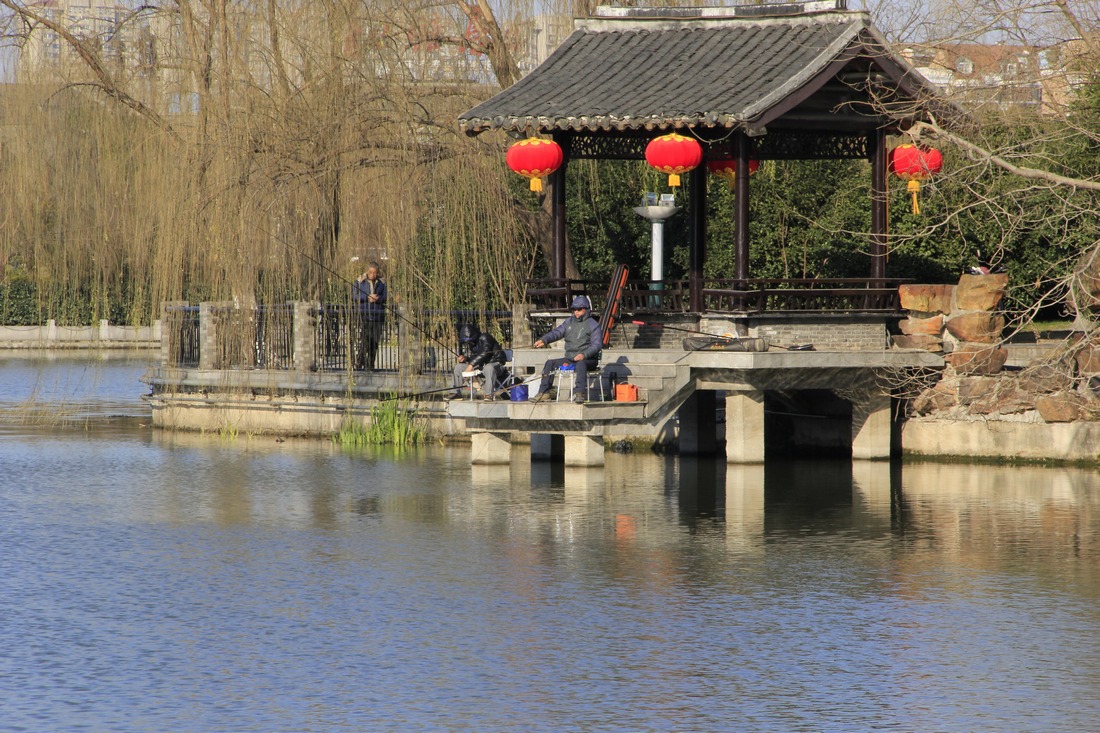 1、	瞧：河对面的景点已经挂起大红灯笼，钓鱼人正在大红灯笼下悠闲地垂钓着，或许是祈望在火红的大红灯笼下 ...