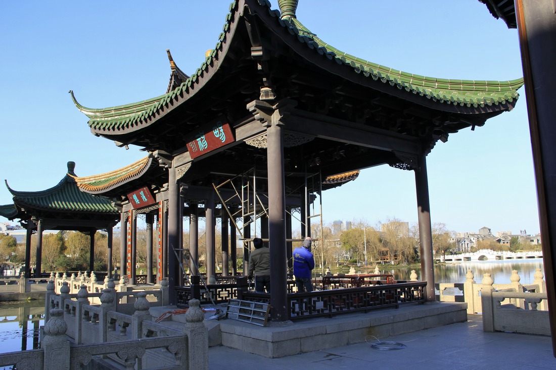 4、	工人正在亭内搭建准备挂大红灯笼的脚手架子。