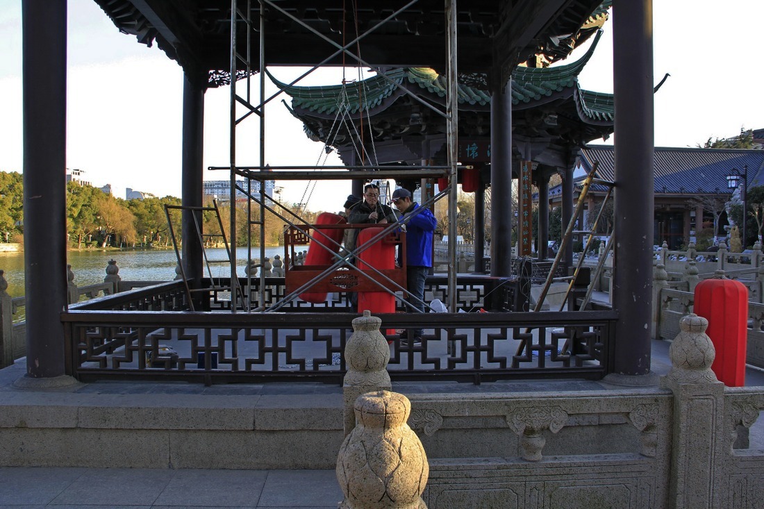 10、	工人把大红灯笼组装到大灯笼架子里。