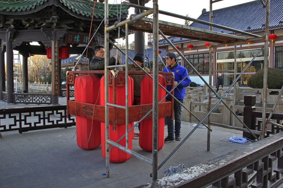 11、	工人把每只灯笼都用铁丝固定起来并连接灯笼的电线。