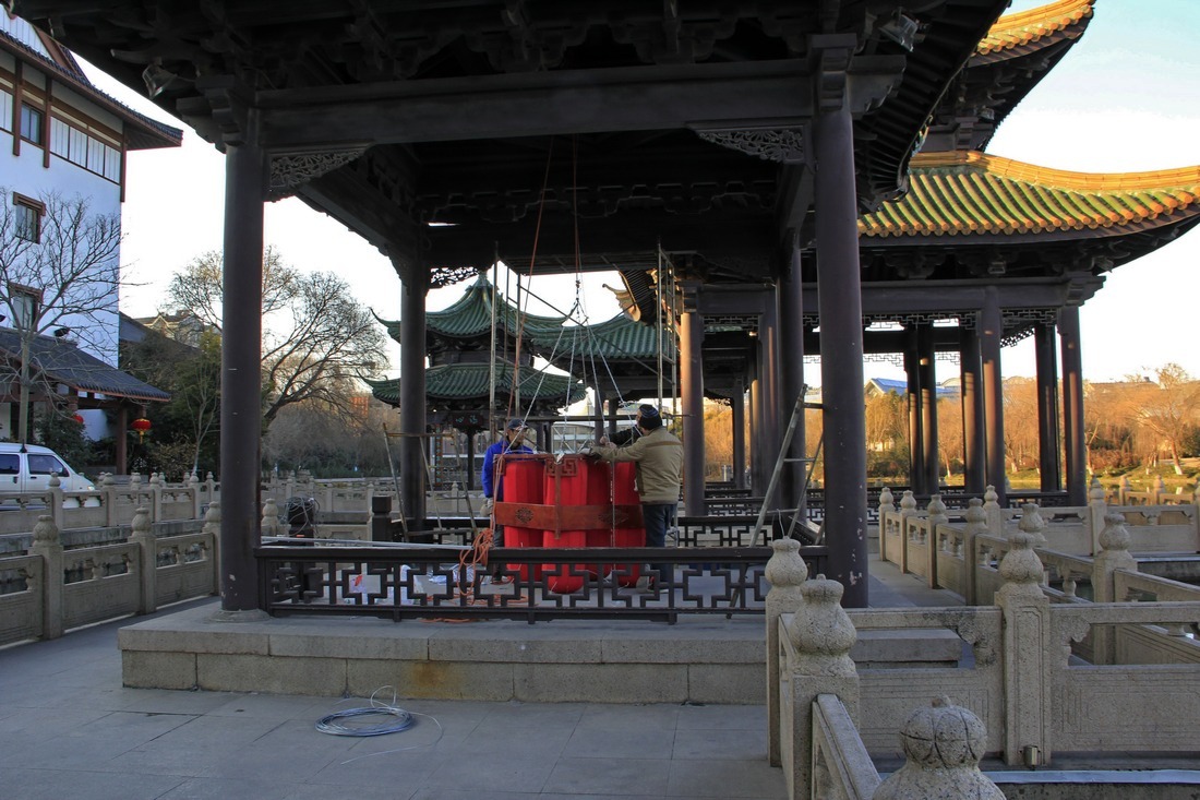 14、	工人准备要把这组重约30公斤的大红灯笼吊挂起来。