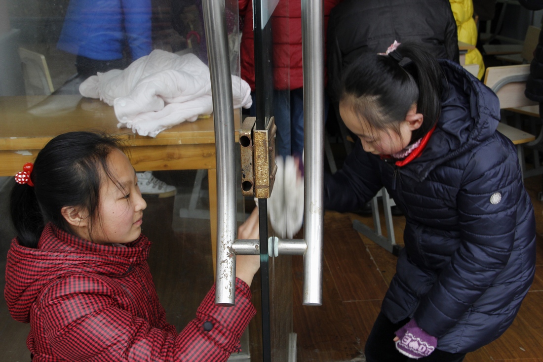 3、	小志愿者帮邻里服务点擦拭玻璃门窗。