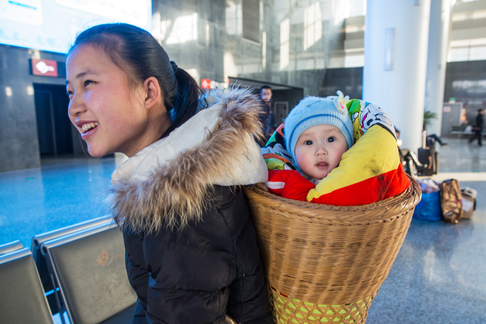 1．年轻妈妈背着一个漂亮的小娃娃