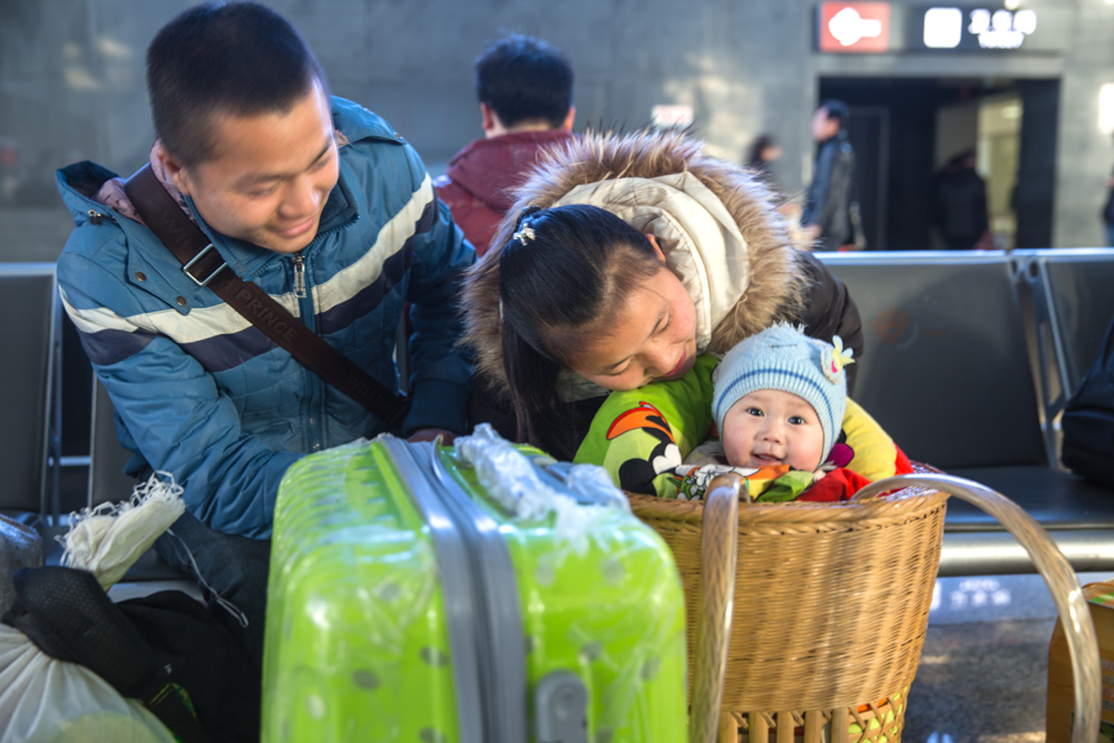 3．候车期间，夫妇俩逗着女儿玩，看着孩子露出的笑脸，小夫妇幸福满满