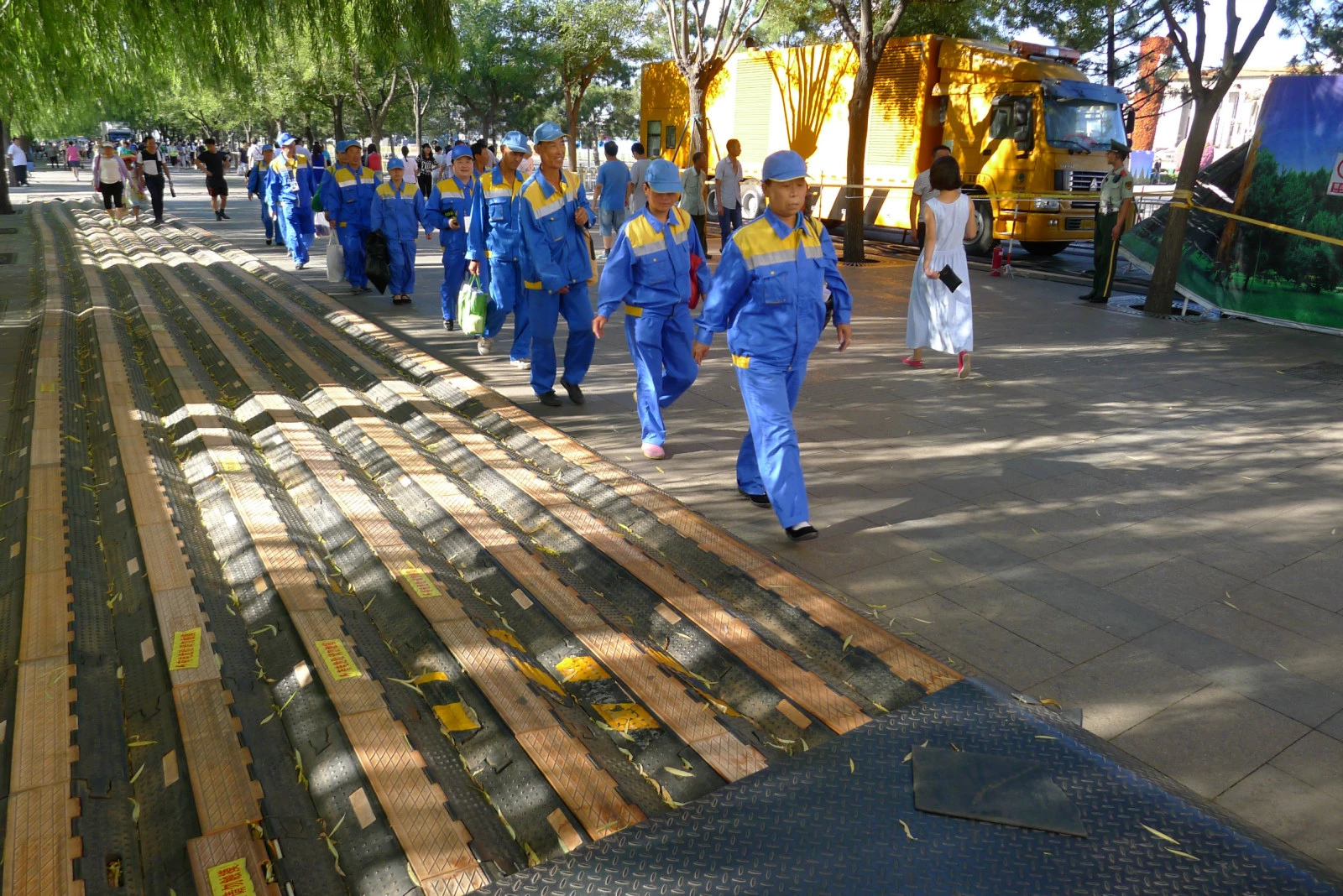 8 地上的线缆保护垫，一队环卫工人走过.jpg