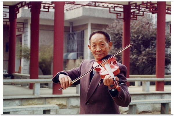 有一次与人对谈，对方提到他 “擅长小提琴”，他会悄悄告诉对方， “其实，后面有人放音乐，我就是拿把琴在前面装装样子而已。” 图为袁隆平拉小提琴（图片：cpcchina.org）