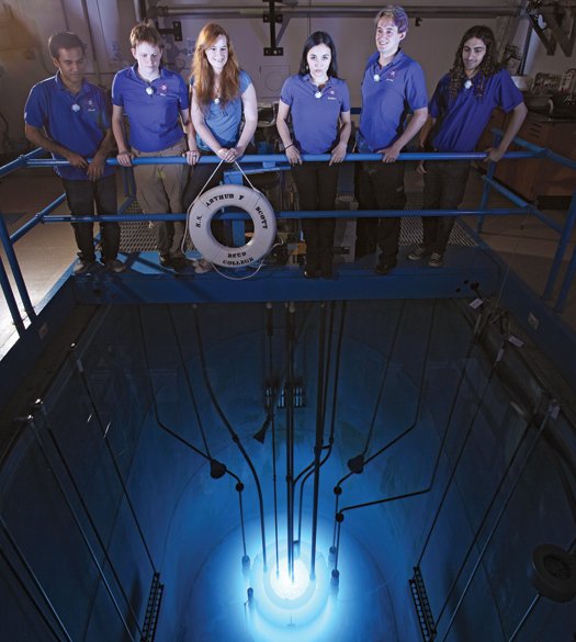 学生站在装着250千瓦的研究型核反应堆的水池上方。图中的蓝色辉光是切连科夫辐射。