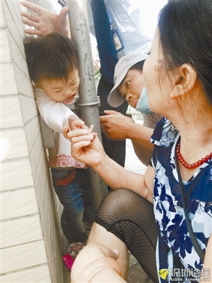 陈先生（戴白帽者）正在拧开管道螺丝救出被卡女孩