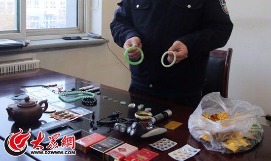 警方展示犯罪嫌疑人盗窃的金银首饰、烟酒、工艺品等赃物。