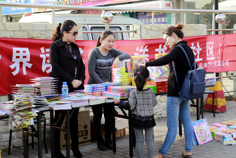 工作人员向居民介绍优秀书籍