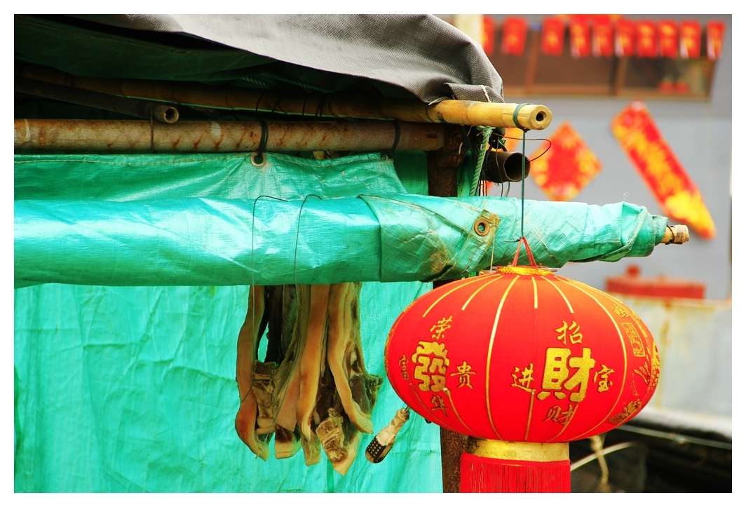 4、	船篷下挂着腊肉和大红灯笼。