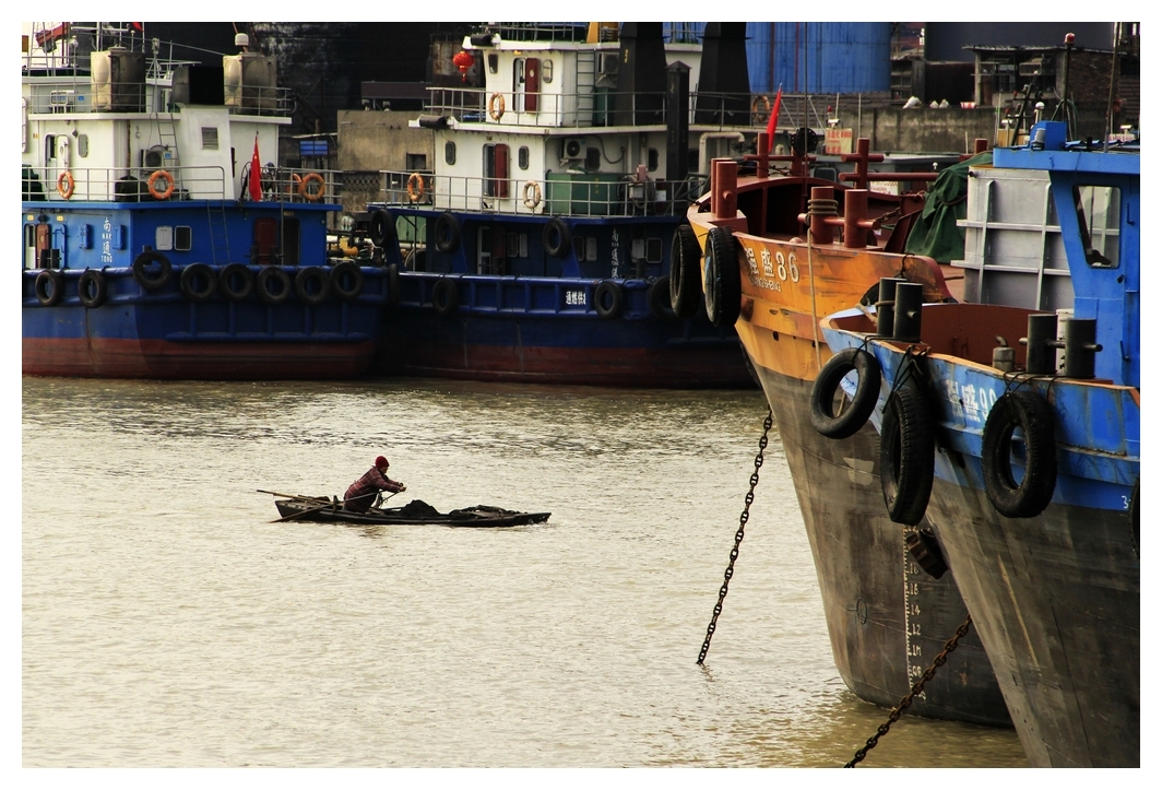 5、	船上阿婆摇着装煤的小舢板回家。