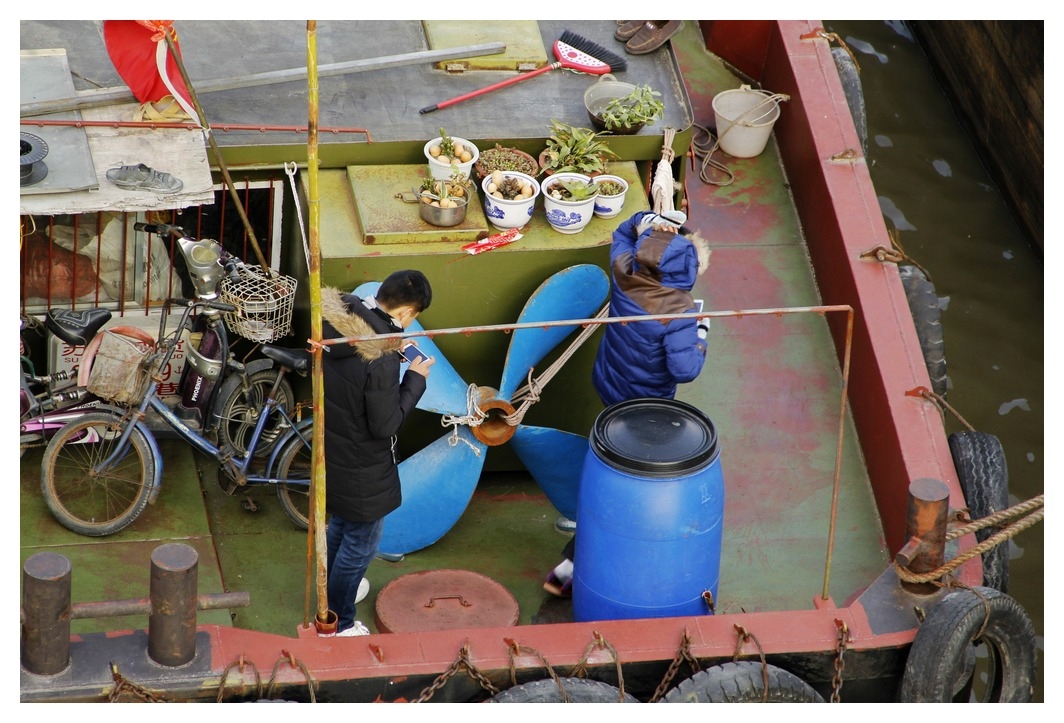 8、	船上少年也喜欢玩着手机。