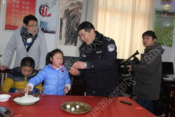 社区民警在教小朋友包元宵.JPG