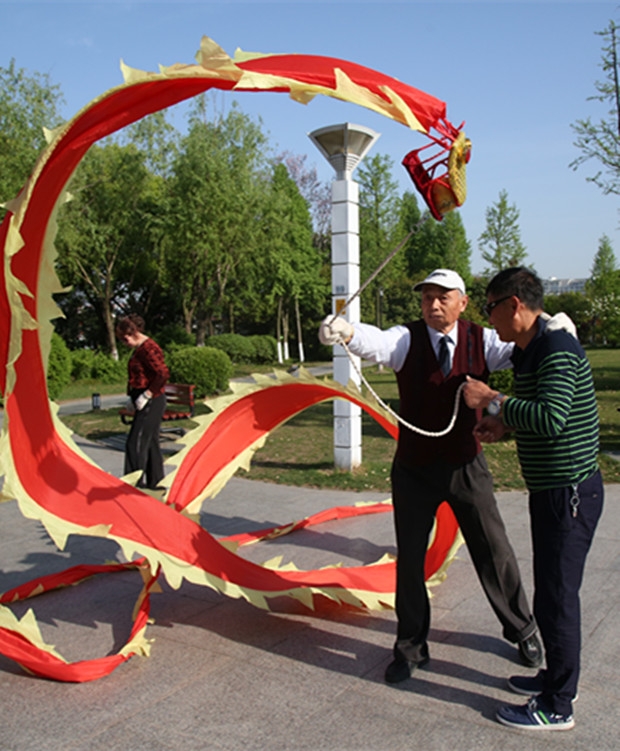 75岁的严师傅在手把手指导对“飘龙”感兴趣的初学者