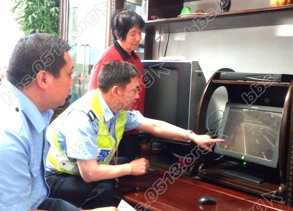 图为白蒲交警中队队长孙增祥（中）在辖区‘警民共建’居民家中调取监控录像。殷建峰 .jpg