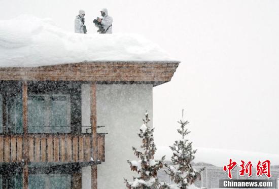达沃斯论坛开幕在即，狙击手屋顶积雪中持枪待命