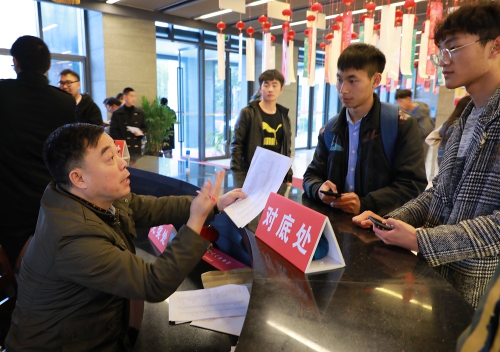 传承人之一的王栋臣会长在航院现场指导学生猜灯谜