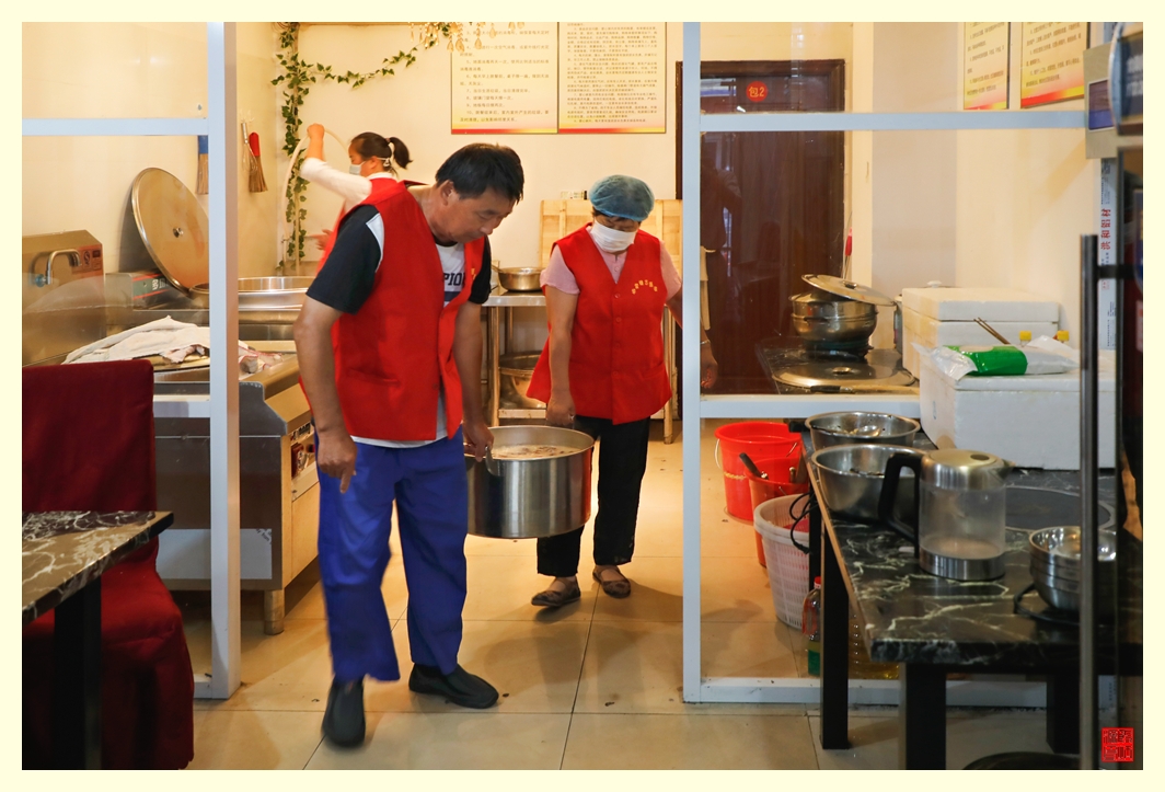 志愿者把一大桶粥提到店门口。