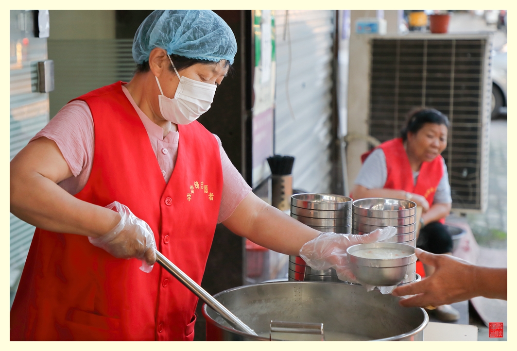 志愿者在一碗一碗盛粥。