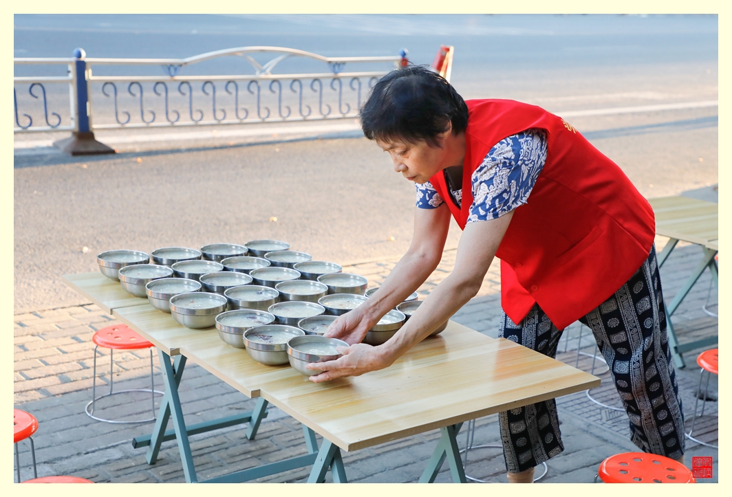 排列整齐的爱心粥在等待就餐人。