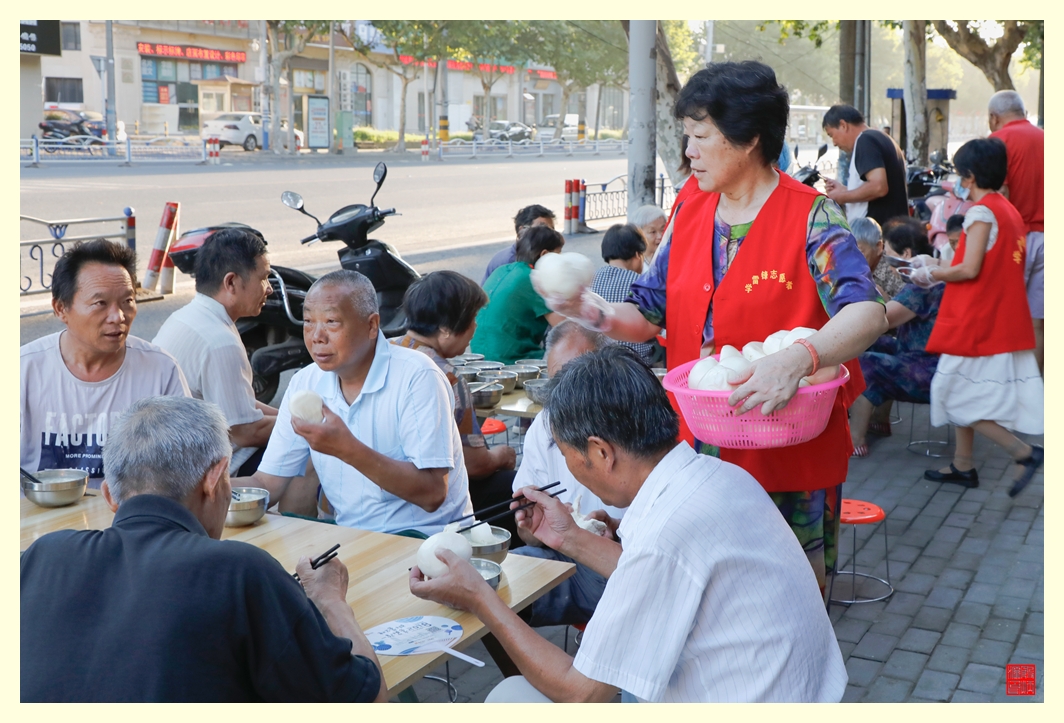 志愿者把免费的馒头发放给每个就餐人。