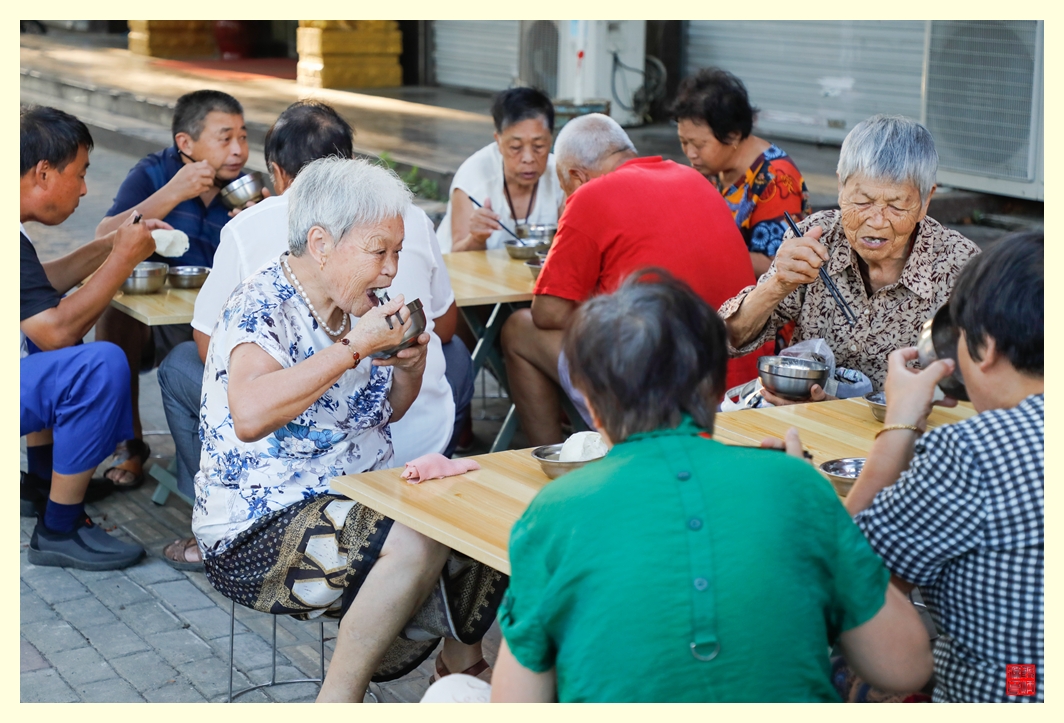 老人们在这里开心的吃着热乎乎的免费爱心粥。