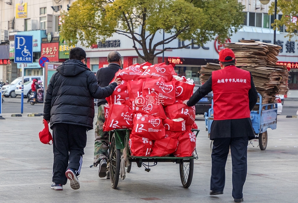 将装好袋的爱心年夜饭从地下室运往捐赠广场