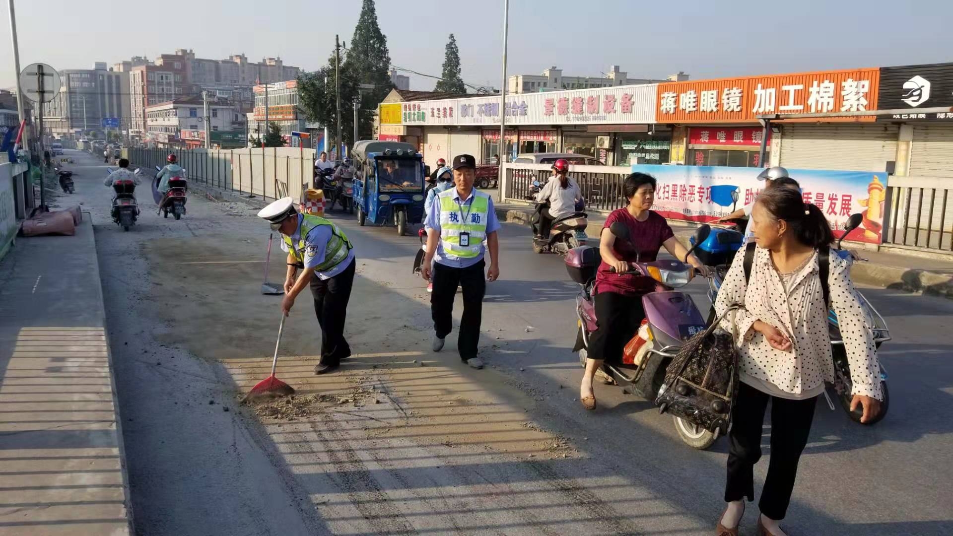 老协管员单忠新和辅警刘云翔在清理桥面油污