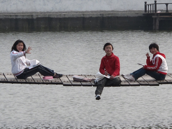 三个坐在悬索桥上读书的女孩。见我拍照，她们有点害羞。