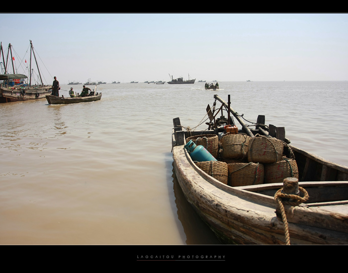 --------------随着潮水的上涨，远处的渔船放下舢板，开始将鱼货送上岸         ------------------------- ...