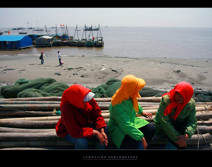 --------------烈日下的海面有些沉郁，几个花头巾静静地坐在岸边，等待着渔船的靠岸。-------------------- ...