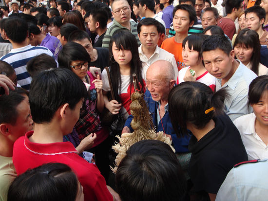 老人叫卖的灯芯草被协警扯掉一大半后，引发路人不满。